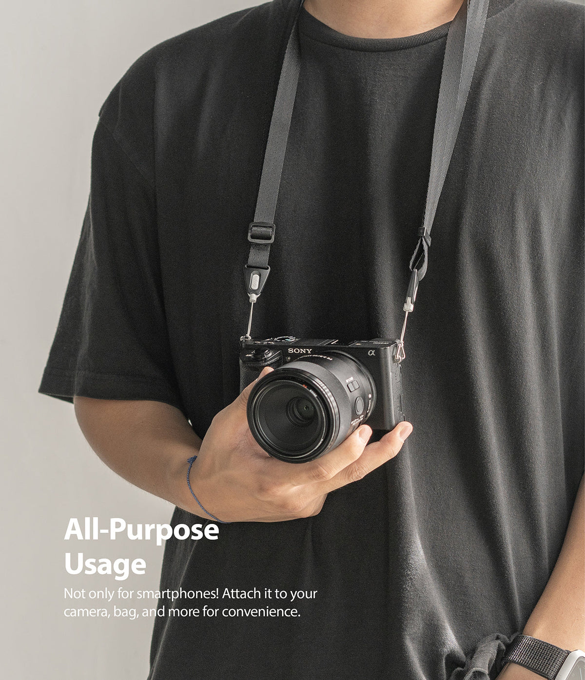 Shoulder Strap | Black / Neon Orange - Person wearing a black camera strap attached to a Sony mirrorless camera.