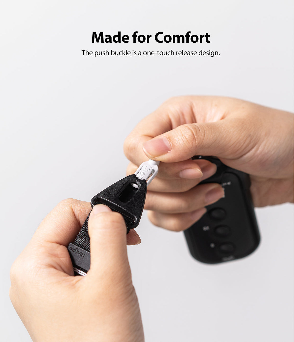Design Shoulder Strap - Hands demonstrating the one-touch release of a black push buckle on a shoulder strap.