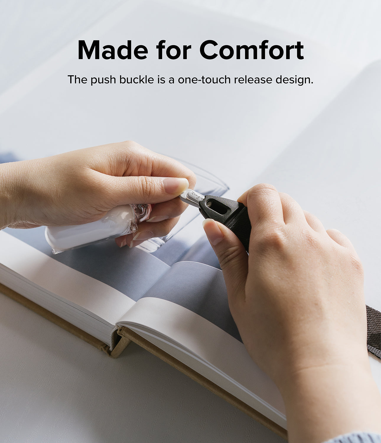 Design Shoulder Strap - Hands demonstrating the one-touch push buckle release mechanism on a black shoulder strap.