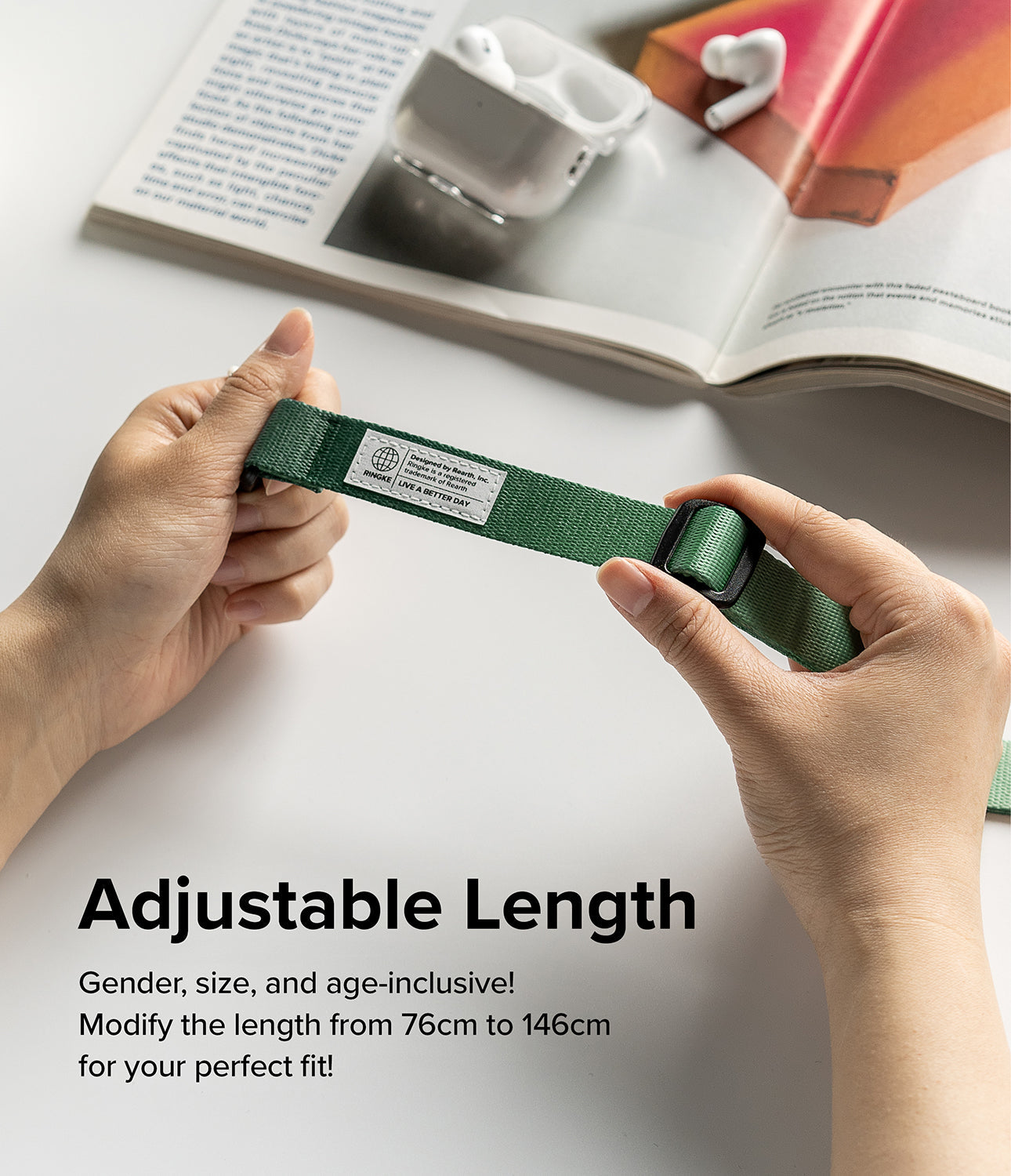 Design Shoulder Strap - Hands adjusting the length of a green fabric strap with a black buckle and branded label.