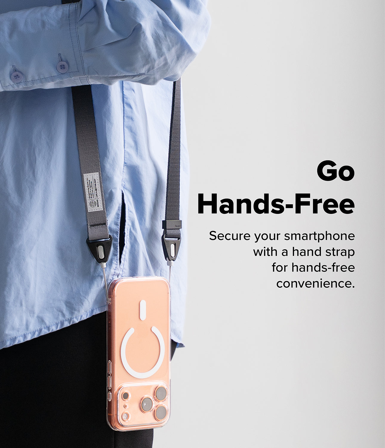 Design Shoulder Strap - A person wearing a gray phone strap attached to a clear smartphone case with a white MagSafe ring.