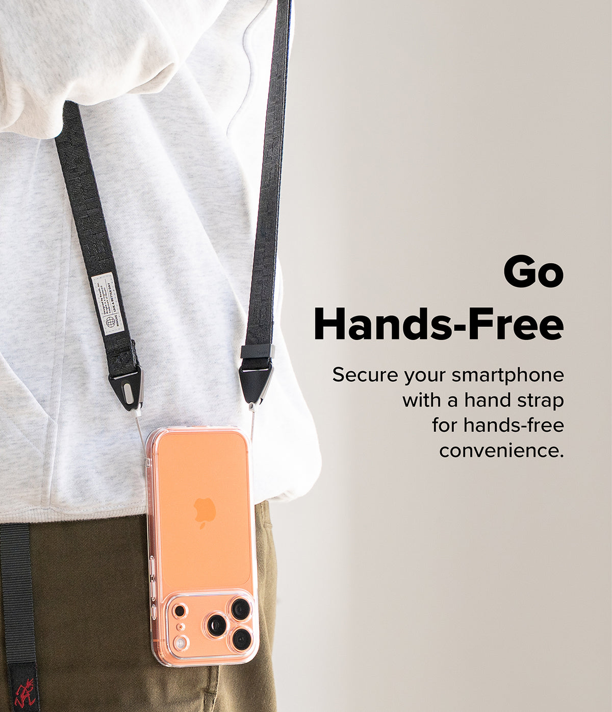 Design Shoulder Strap - A person wearing a black phone shoulder strap attached to a clear case with an orange smartphone.