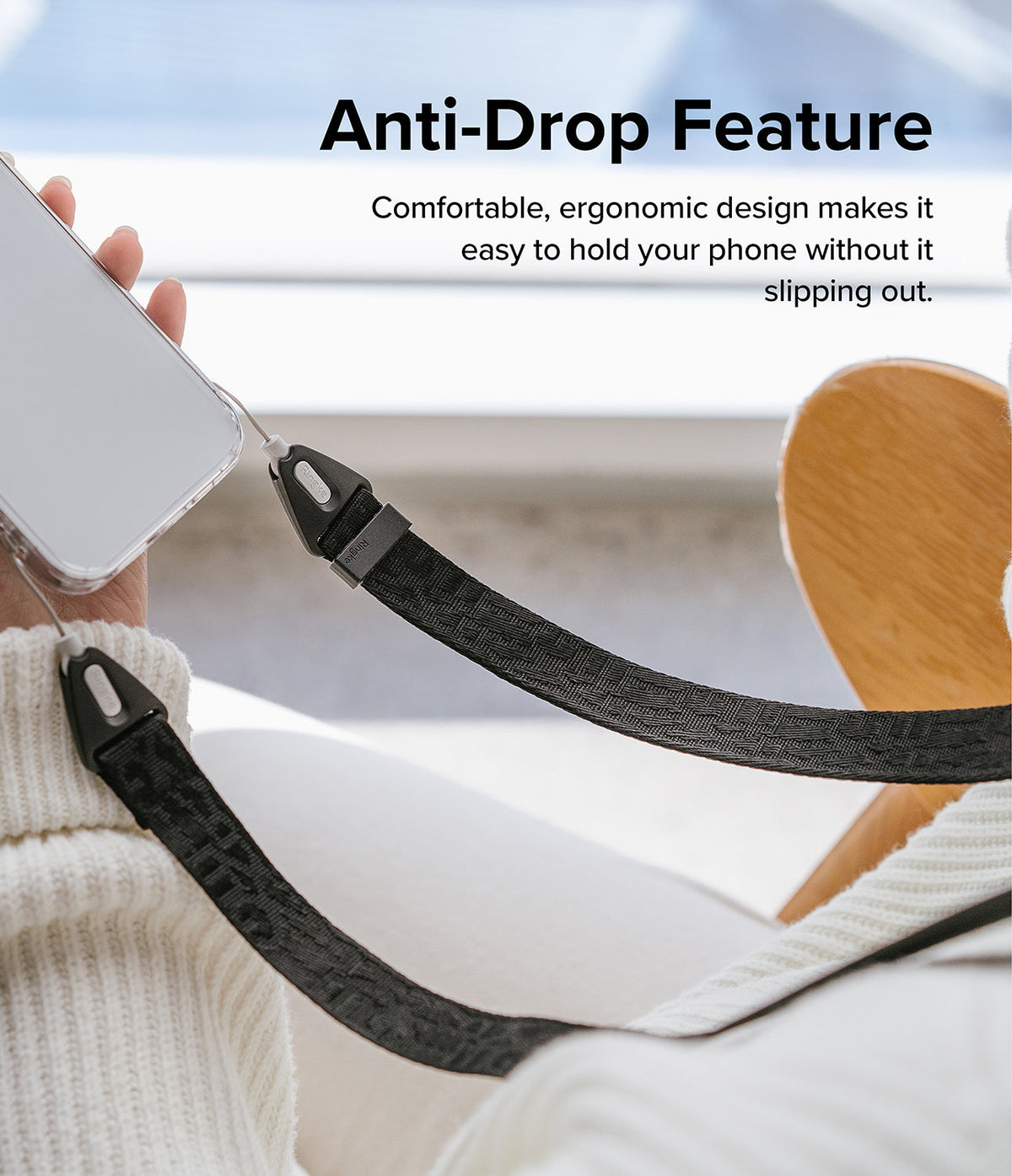 Design Shoulder Strap - A hand holding a smartphone attached to a black patterned fabric strap with ergonomic connectors.