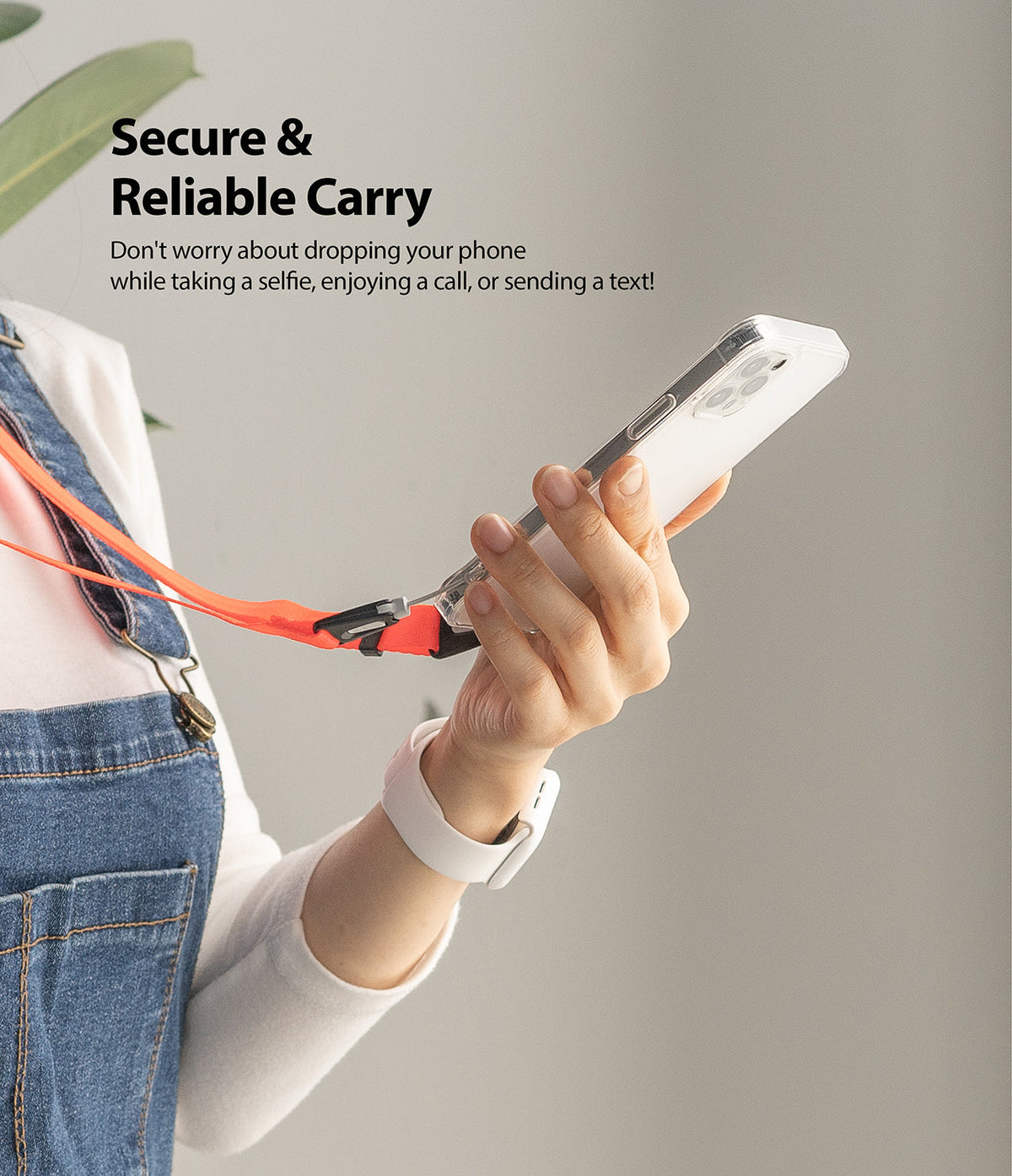 Shoulder Strap | Black / Neon Orange - Person holding a phone attached to a bright neon orange shoulder strap.