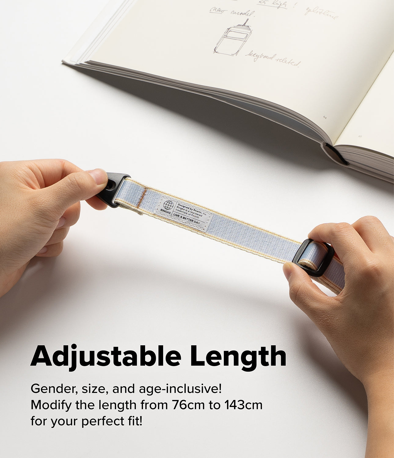 Design Shoulder Strap - Hands adjusting the length of a light gray woven strap with a Ringke brand label and black hardware.