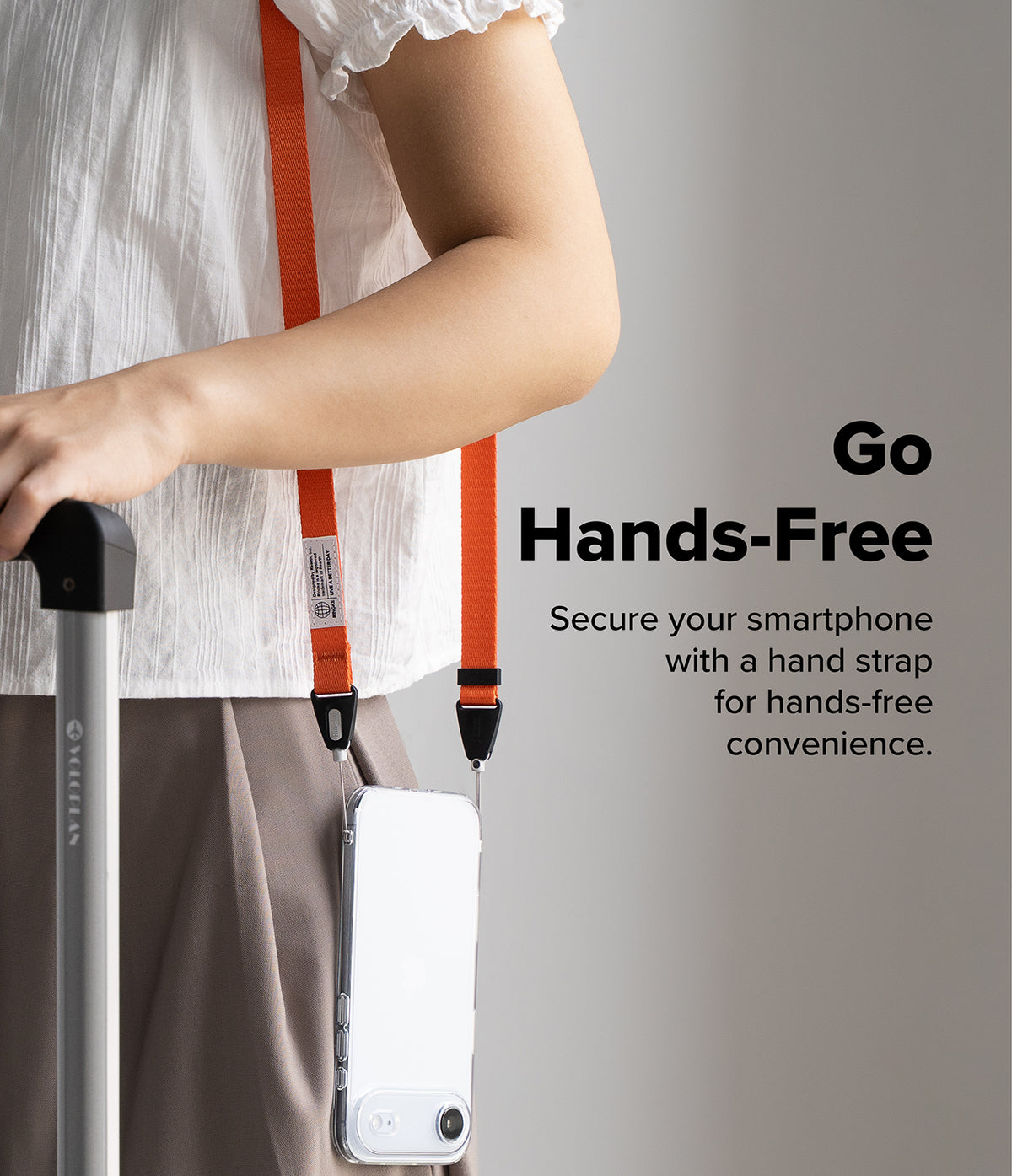 Shoulder Slim Strap - Person wearing an orange phone shoulder strap with a clear phone case, holding a suitcase handle.