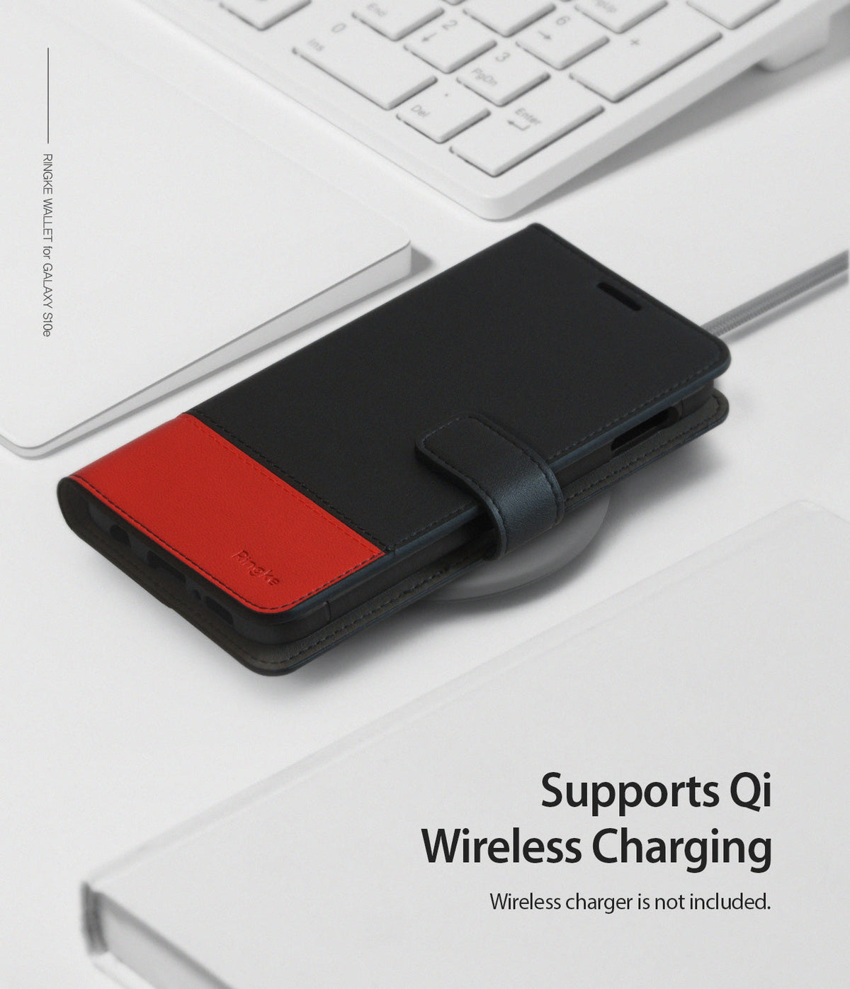 Galaxy S10e Case | Wallet - Black and red leather wallet case on a wireless charging pad near a white keyboard.
