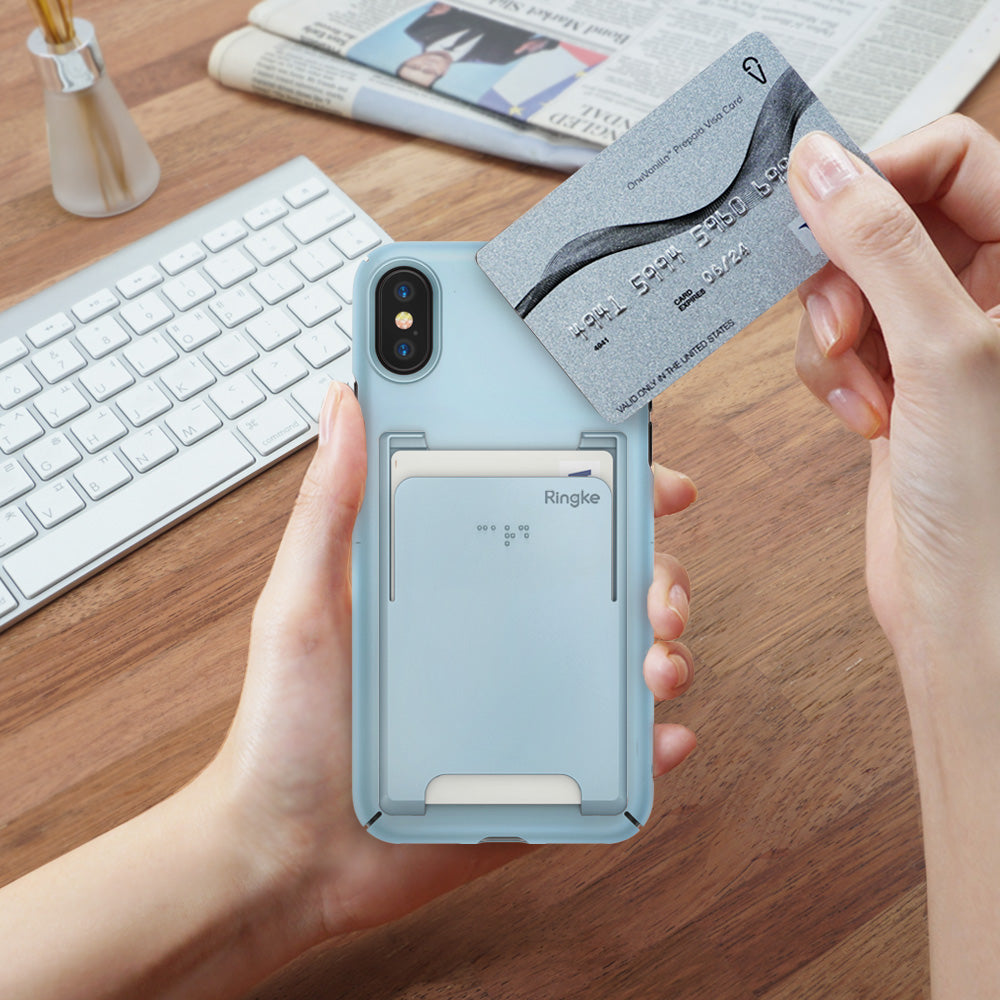 iPhone X Case | Slim + Slot Card Holder - Hands holding a sky blue phone case with a card slot, inserting a credit card.