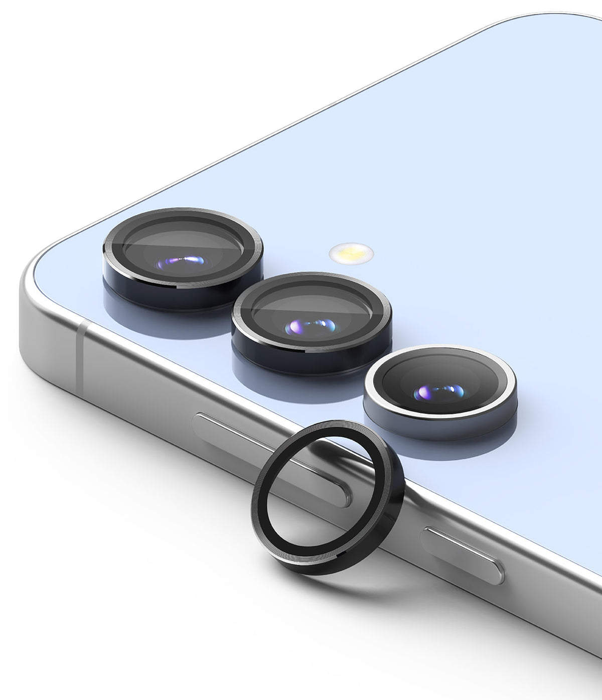 Galaxy S24 FE | Camera Lens Frame Glass - Three black lens protectors on a light blue phone with one detached ring.