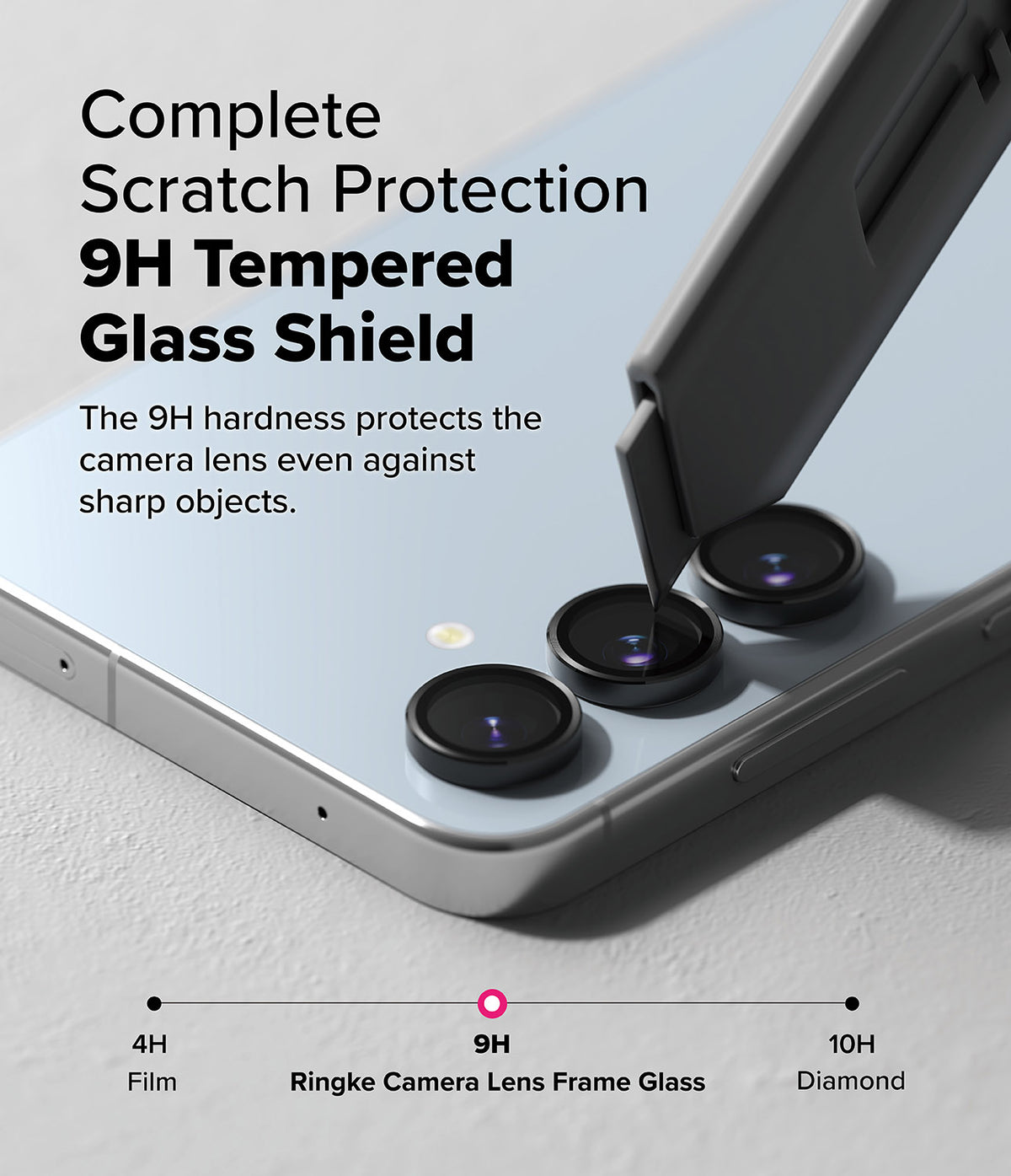 Galaxy S24 FE | Camera Lens Frame Glass - A utility knife scrapes a 9H tempered glass camera lens protector on a phone.
