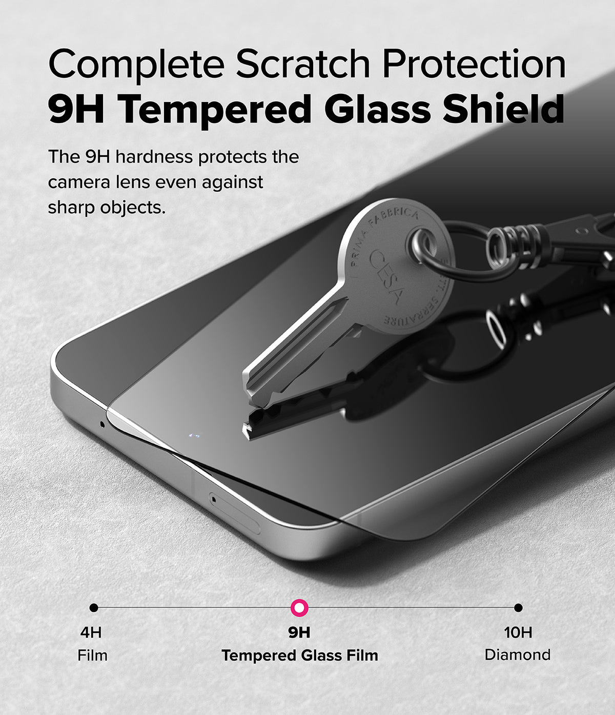 Galaxy S24 FE Screen Protector | Easy Slide Tempered Glass - Galaxy S24 FE Screen Protector - A metal key resting on a 9H tempered glass screen protector atop a smartphone.