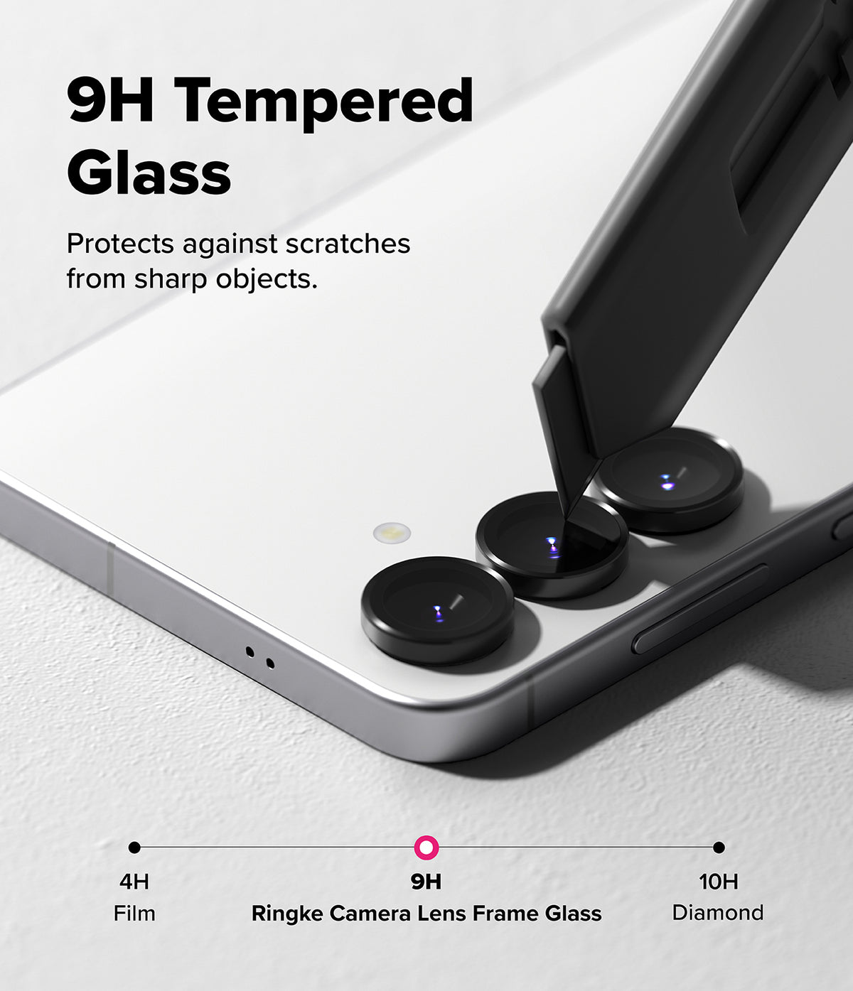 Galaxy S25 FE | Camera Lens Frame Glass - Galaxy S25 FE - A utility knife blade scratches against a 9H tempered glass camera lens protector on a smartphone.