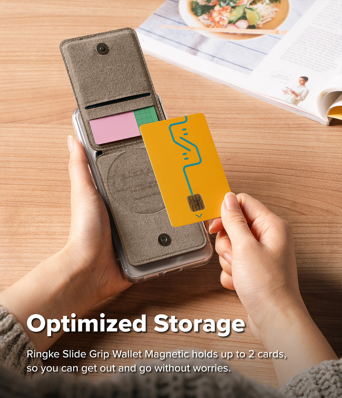 Card Holder | Slide Grip Wallet Magnetic - Hands holding a magnetic phone wallet with two card slots on a wooden desk.