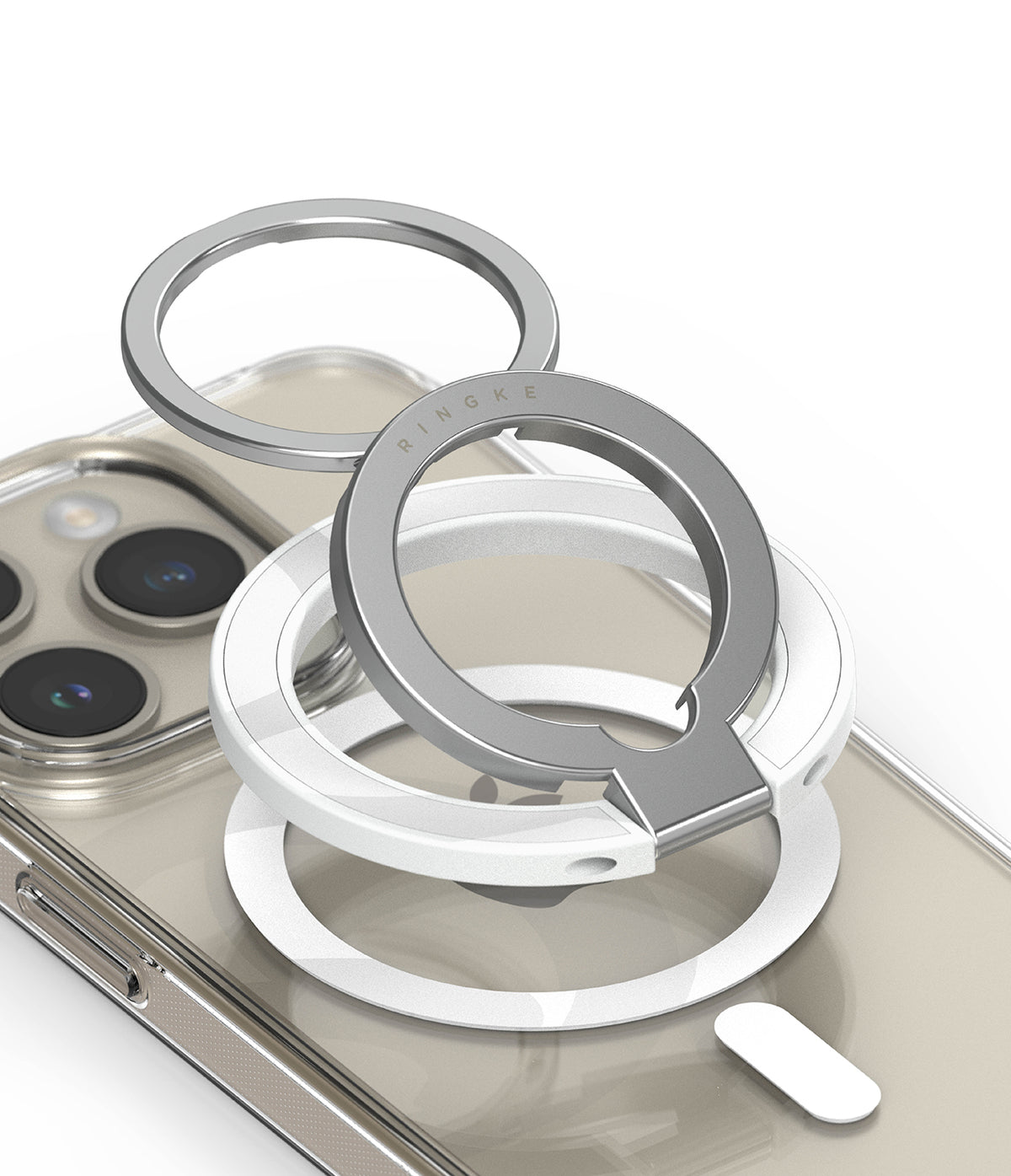 Ringke Smart Ring Magnetic - Stacked silver and white magnetic phone rings resting on a clear smartphone case.