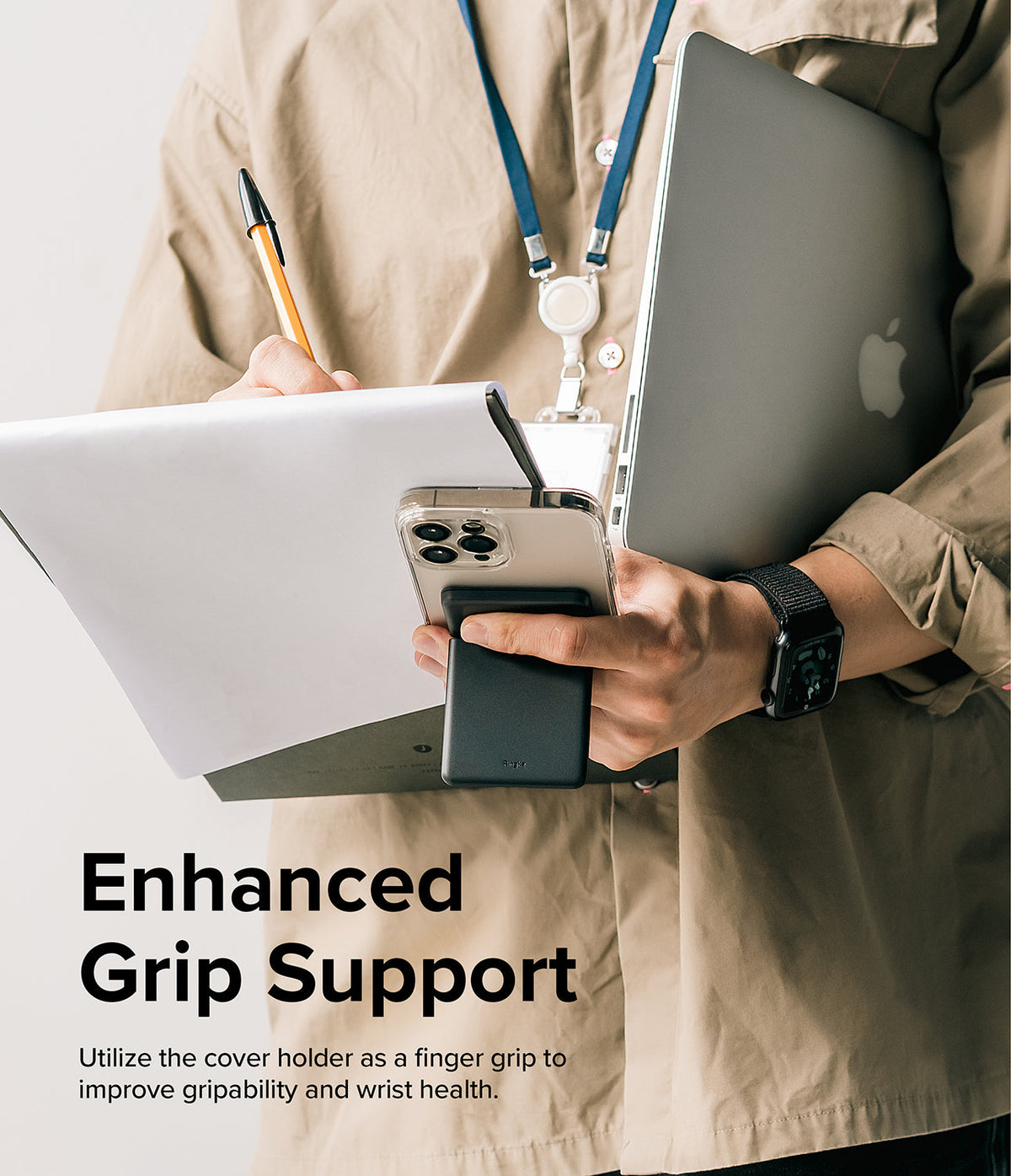 Card Holder | Stand Slot - Person holding a smartphone with a black magnetic card holder acting as a finger grip while carrying a laptop.