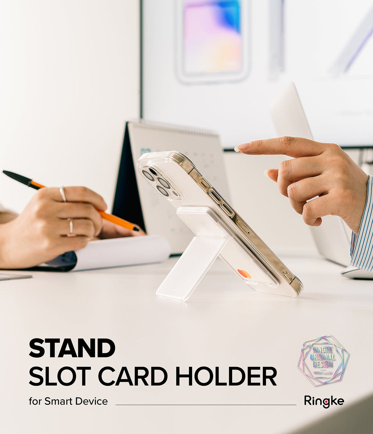 Card Holder | Stand Slot - A clear phone case with a white card holder stand attached, propped up on a desk during a meeting.