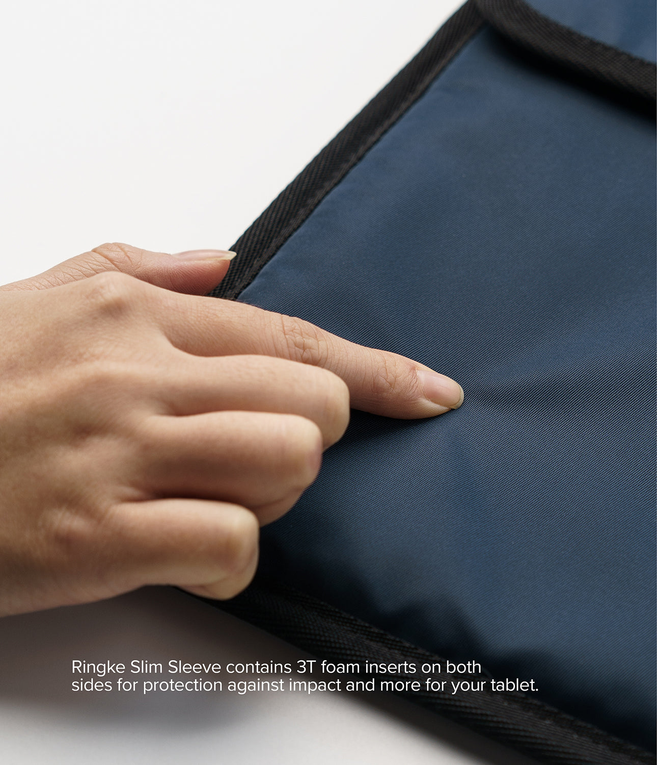 Pad Pouch | Slim Sleeve - A hand presses against the smooth, navy blue fabric surface of a protective tablet sleeve.