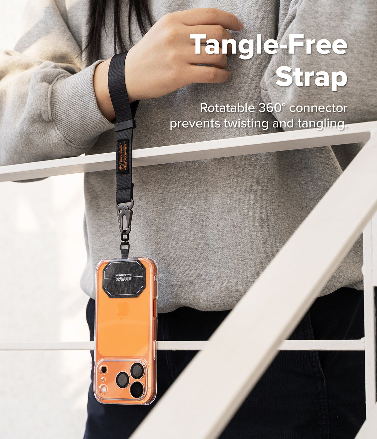Holder Link Tactical Webbing Hand Strap - A black tactical wrist strap attached to an orange phone case with a 360-degree rotatable connector.