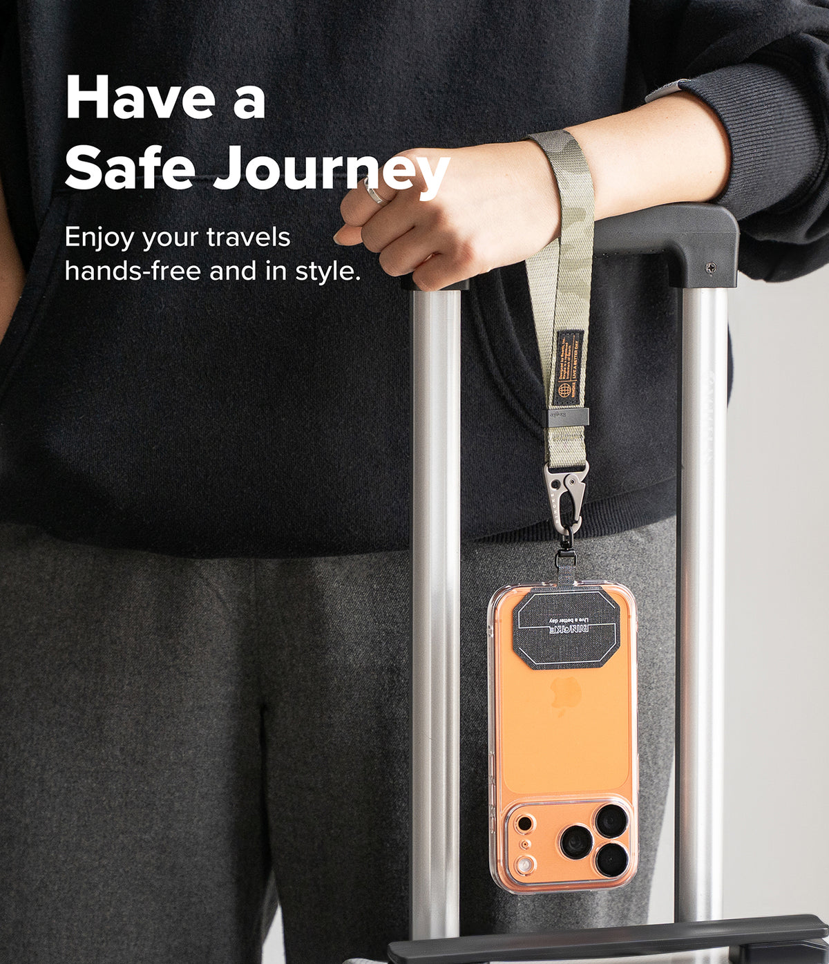 Holder Link Tactical Webbing Hand Strap - Camo webbing strap attached to a phone case hanging from luggage handle.