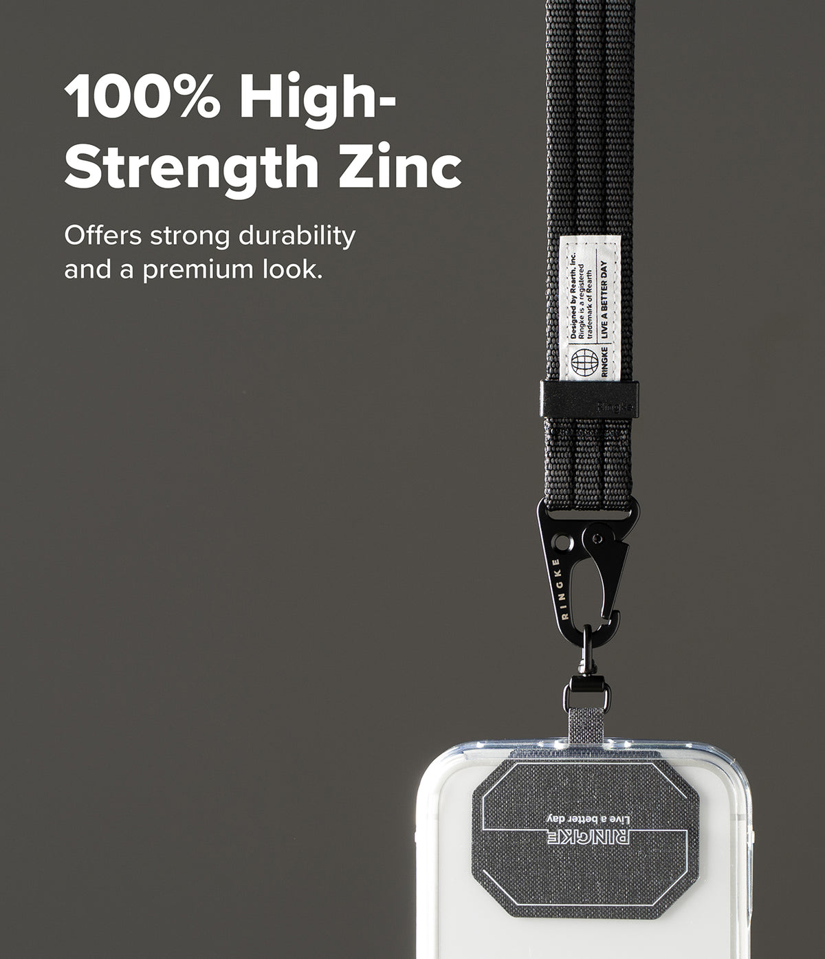 Holder Link Tactical Webbing Hand Strap - A close-up of a black fabric lanyard with a metal clasp attached to a clear phone case, shown against a dark gray background with promotional text reading '100% High-Strength Zinc'.