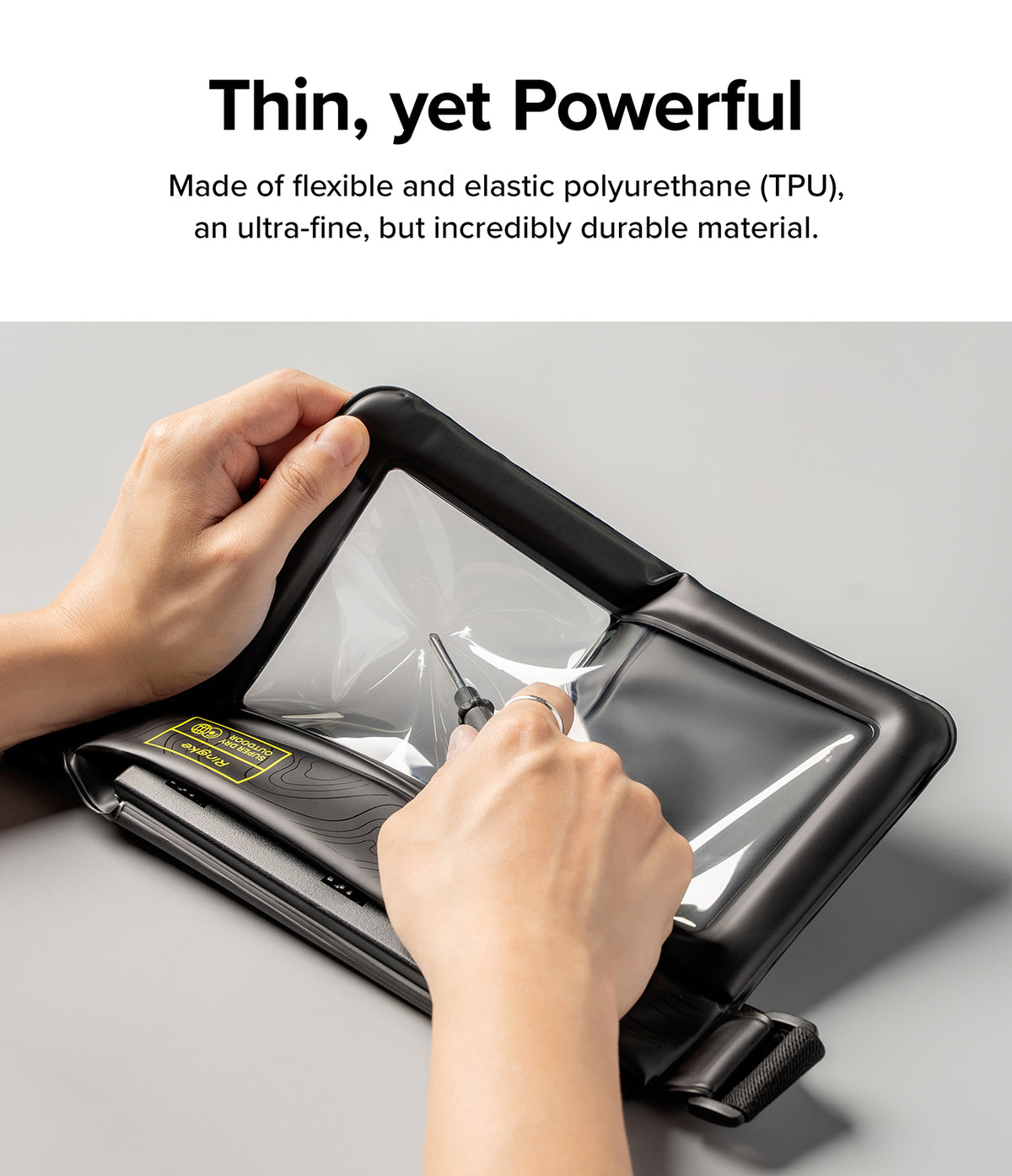 Waterproof Pouch Case | Sling Bag - Waterproof Pouch Case - Hands testing the durability of a flexible TPU waterproof pouch with a pointed tool.