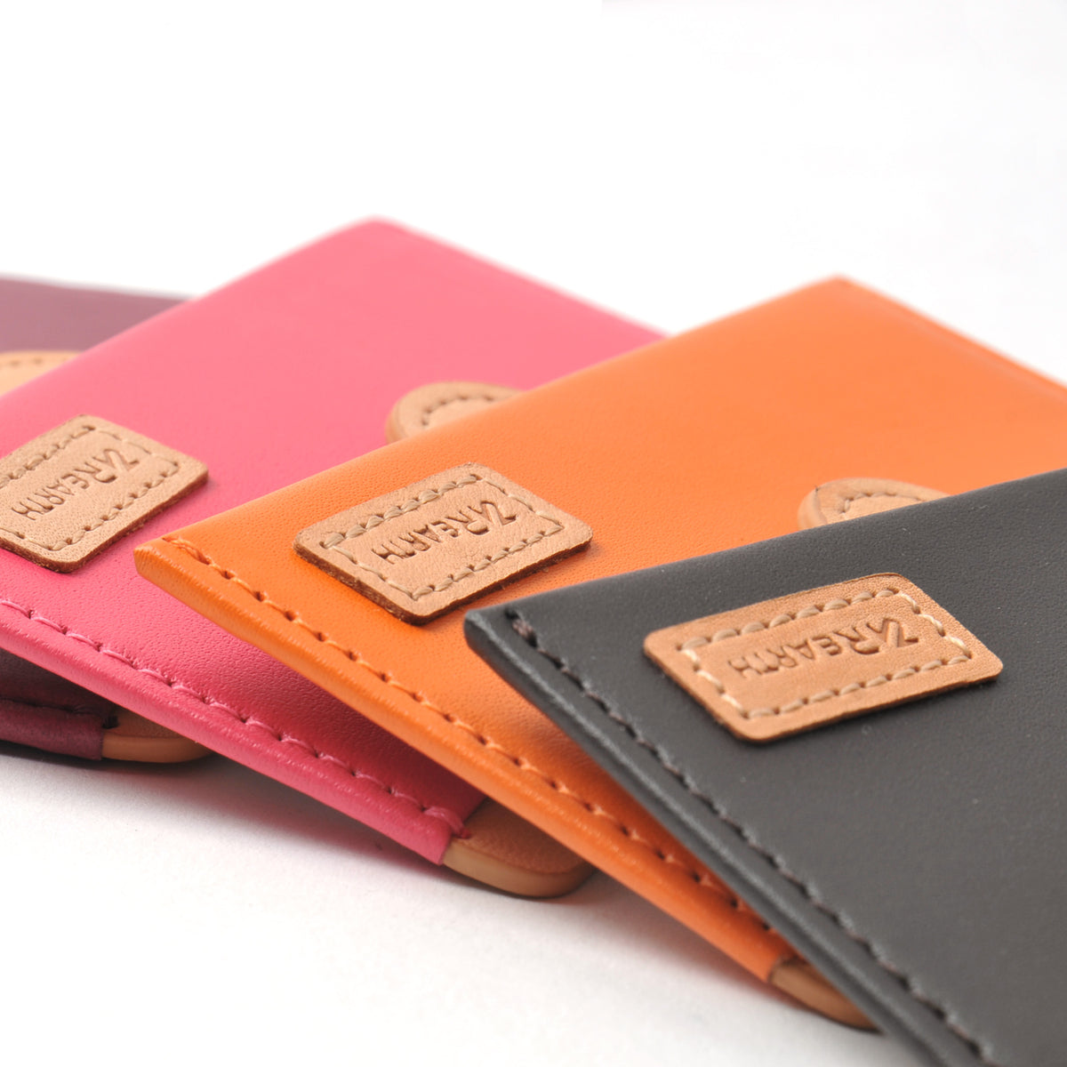 Card Holder | Genuine Leather - Orange - Stack of colorful leather card holders with stitched tan logo patches.