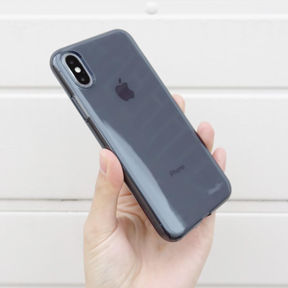 iPhone X Case | Air - A hand holding a translucent smoke black iPhone X case against a white slatted background.