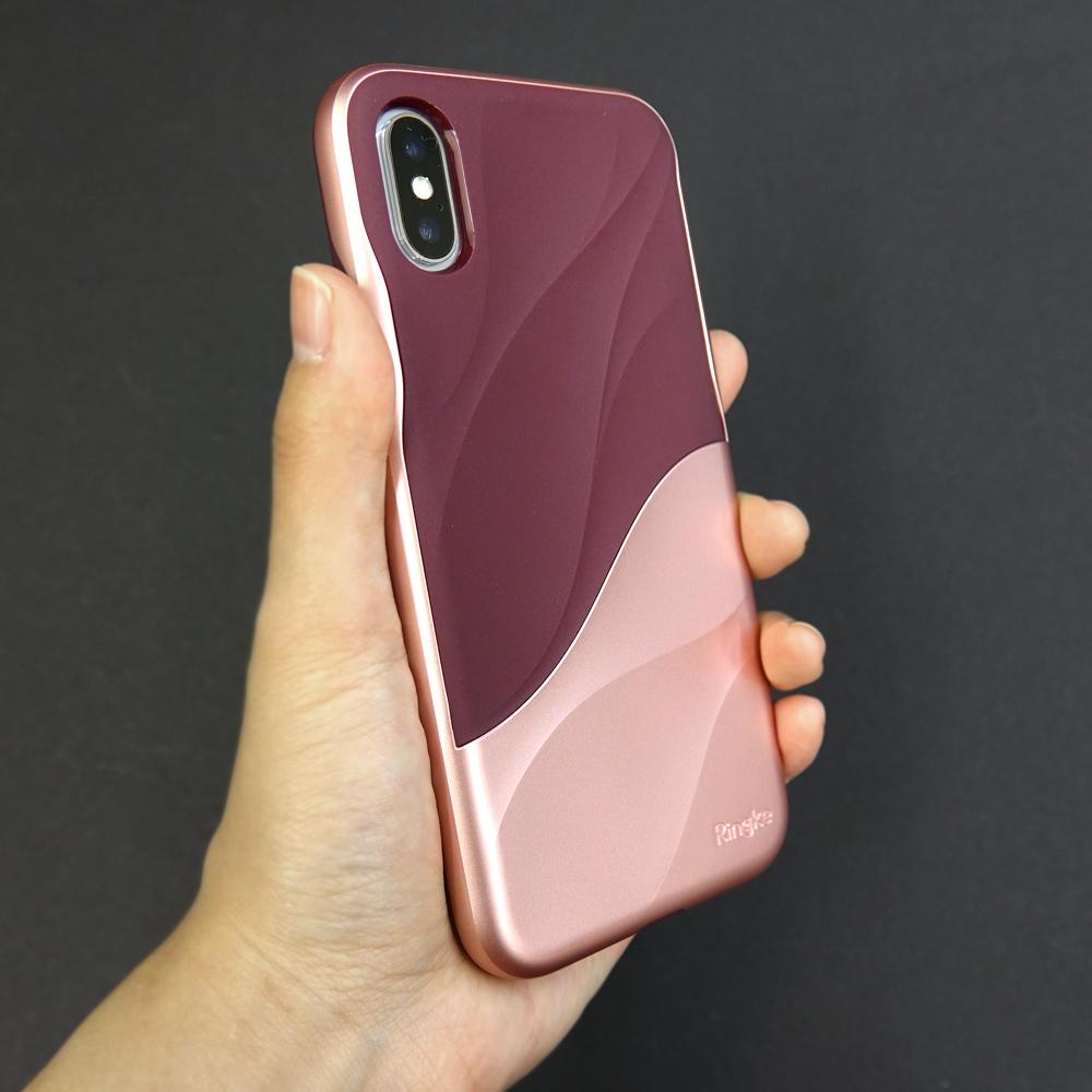iPhone X Case | Wave - Hand holding a two-tone burgundy and rose gold phone case with a textured, wavy design.