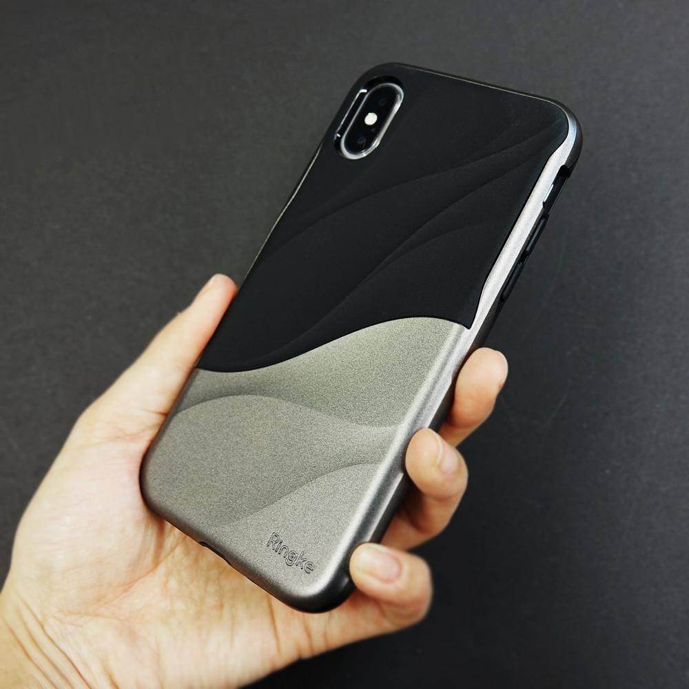 iPhone X Case | Wave - A hand holds a black and metallic silver iPhone case with a textured, wavy design and Ringke branding.