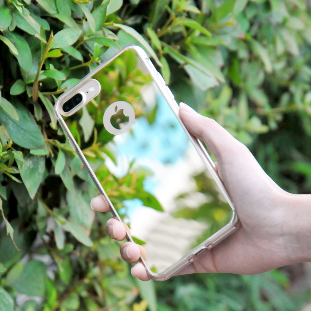 iPhone 7 Case | Mirror - Hand holding a reflective mirror-finish phone case against a background of green foliage.