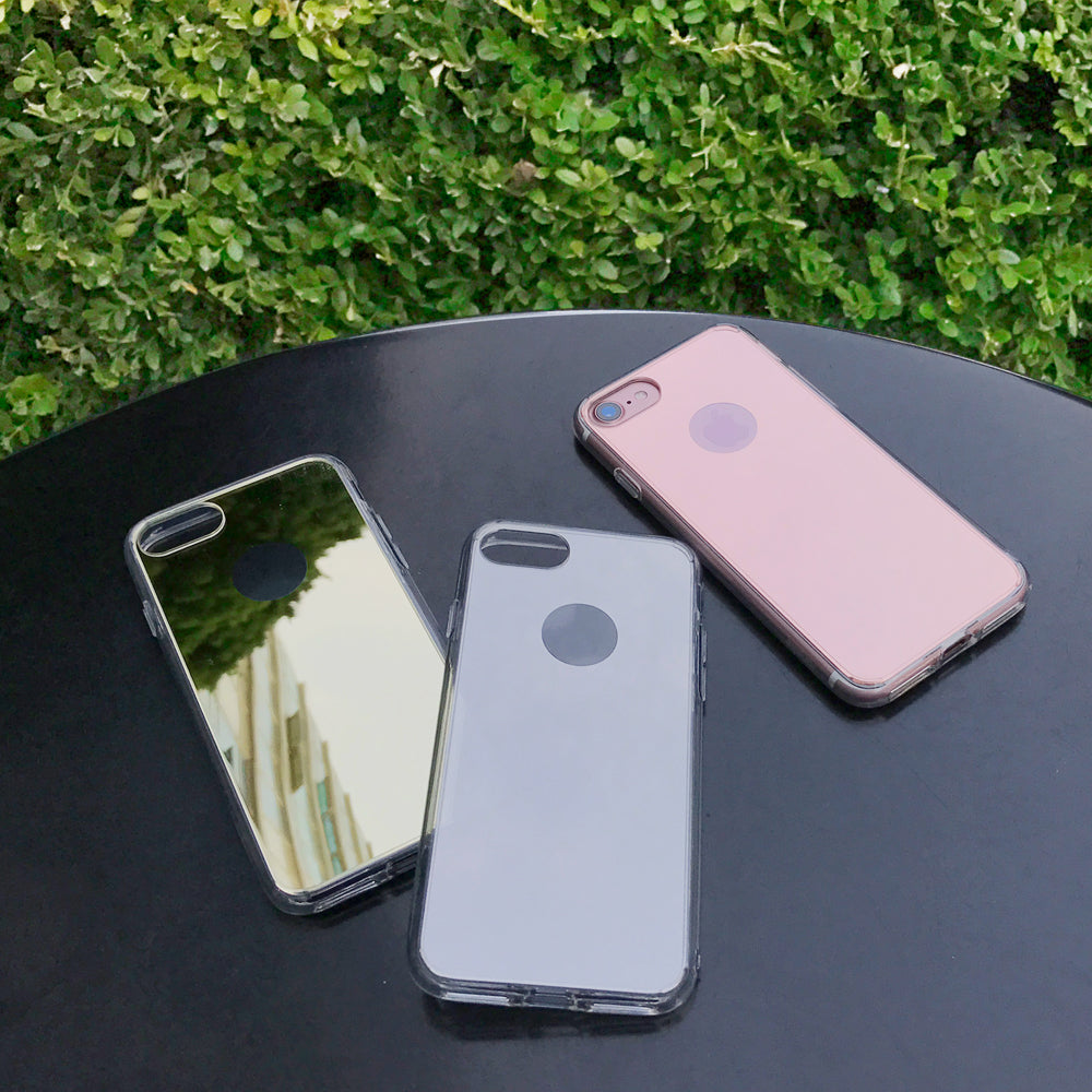 iPhone 7 Case | Mirror - Three iPhone 7 cases in mirror, clear, and rose gold finishes resting on a black table outdoors.