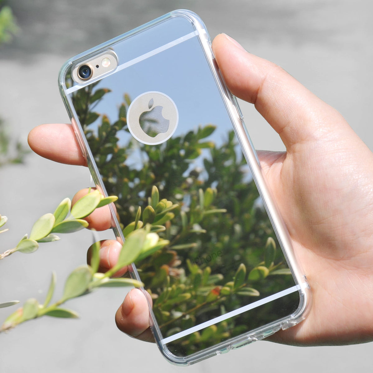 iPhone 6s / 6 Case | Mirror - Hand holding a reflective mirror-finish iPhone case reflecting green foliage outdoors.