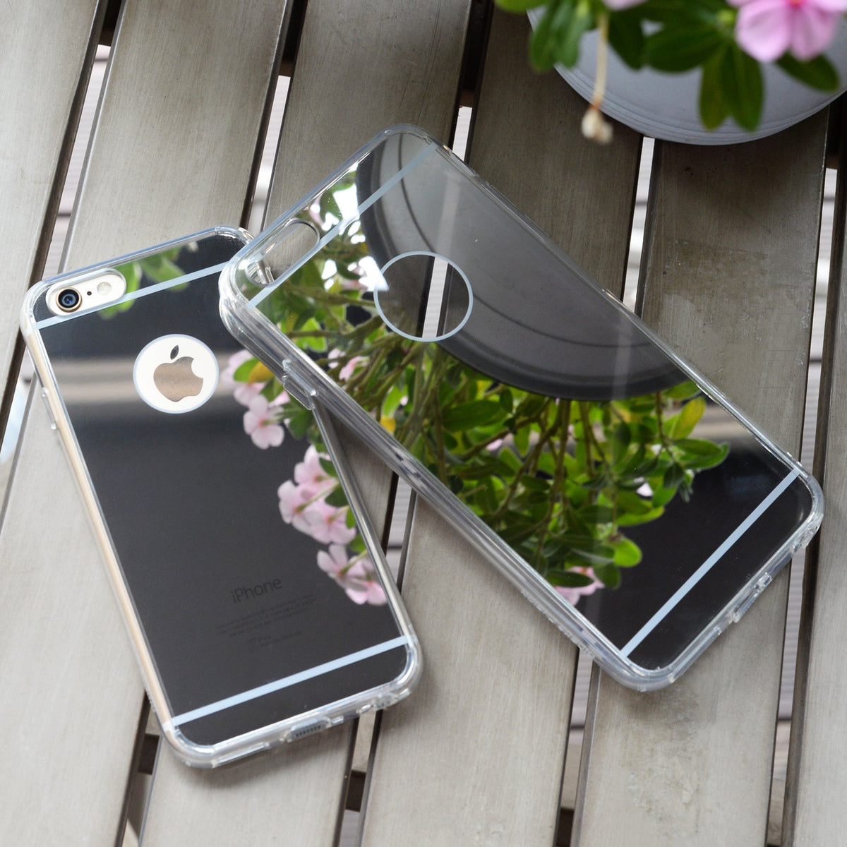 iPhone 6s / 6 Case | Mirror - Two reflective mirror-finish phone cases resting on a wooden table, reflecting nearby flowers.