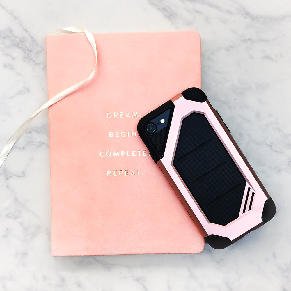 iPhone 8 / 7 Case | Max - Rugged pink and black phone case resting on a pink journal with gold text on a marble surface.