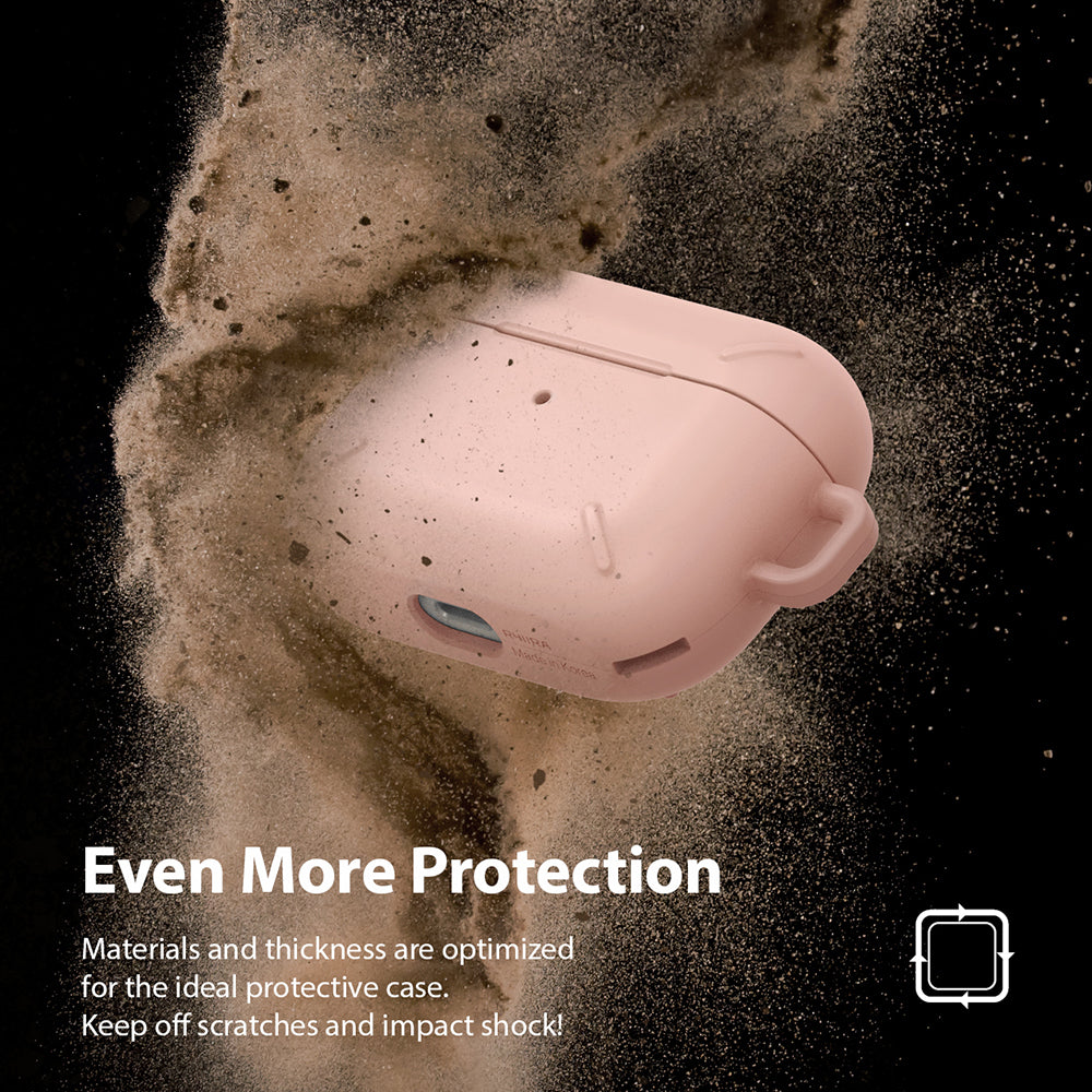 AirPods Pro Case - Peach Pink - A peach pink AirPods Pro case surrounded by a cloud of dust against a black background.