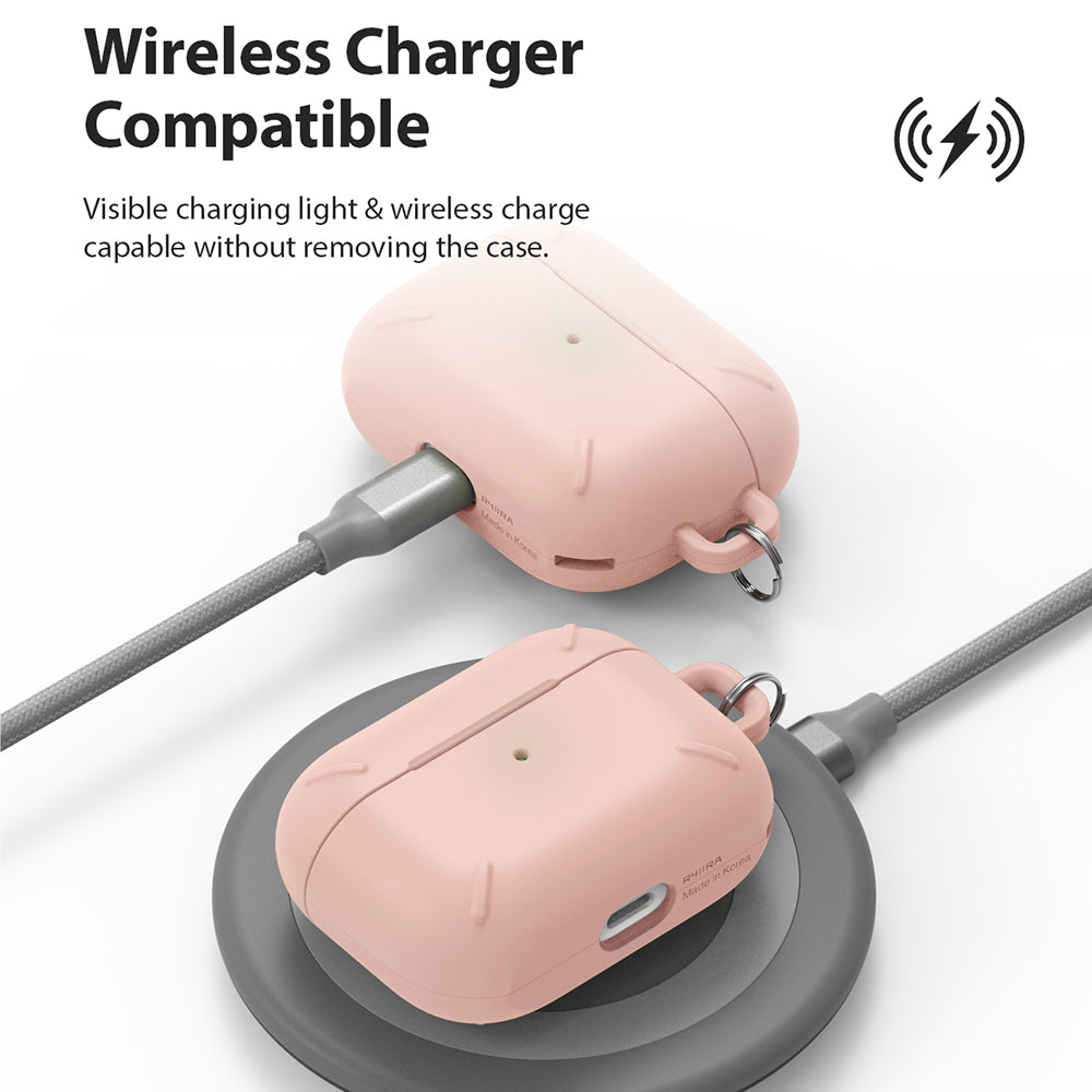 AirPods Pro Case - Peach Pink - Two peach pink AirPods Pro cases, one charging via cable and one on a wireless pad.
