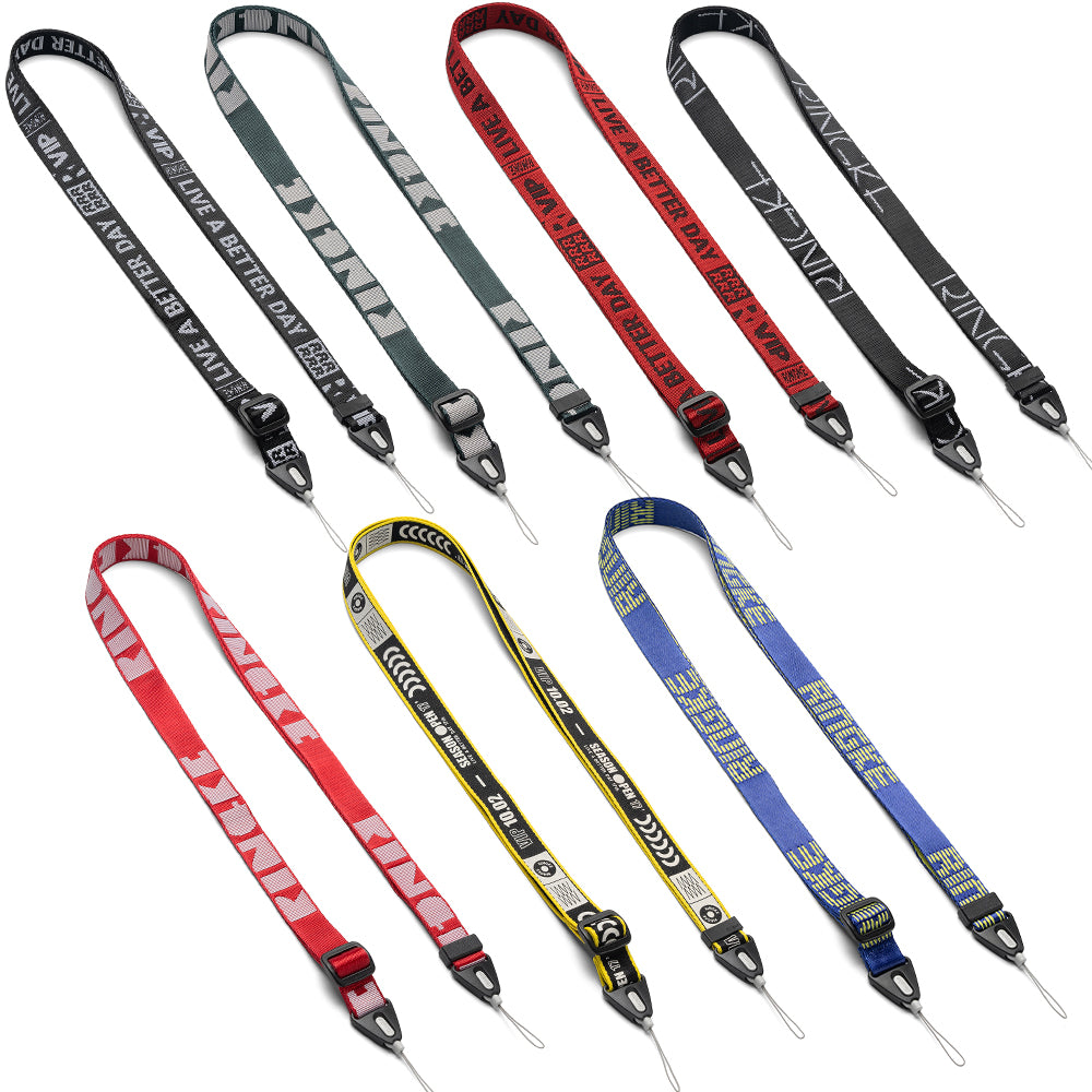 Shoulder Strap | Lettering - Seven colorful fabric camera straps with various branded text and patterns arranged on white.