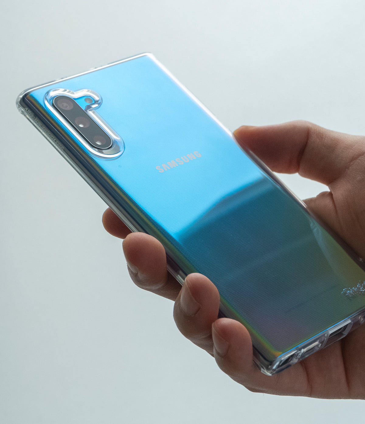 Galaxy Note 10 Case | Air - Clear (Dot) - Hand holding a blue iridescent Galaxy Note 10 in a clear, dotted protective case.