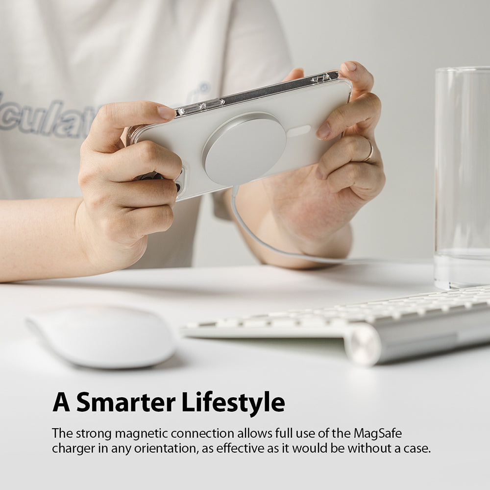 iPhone 12 / 12 Pro Case | Fusion Magnetic - Hands holding an iPhone in a clear case attached to a magnetic charger.