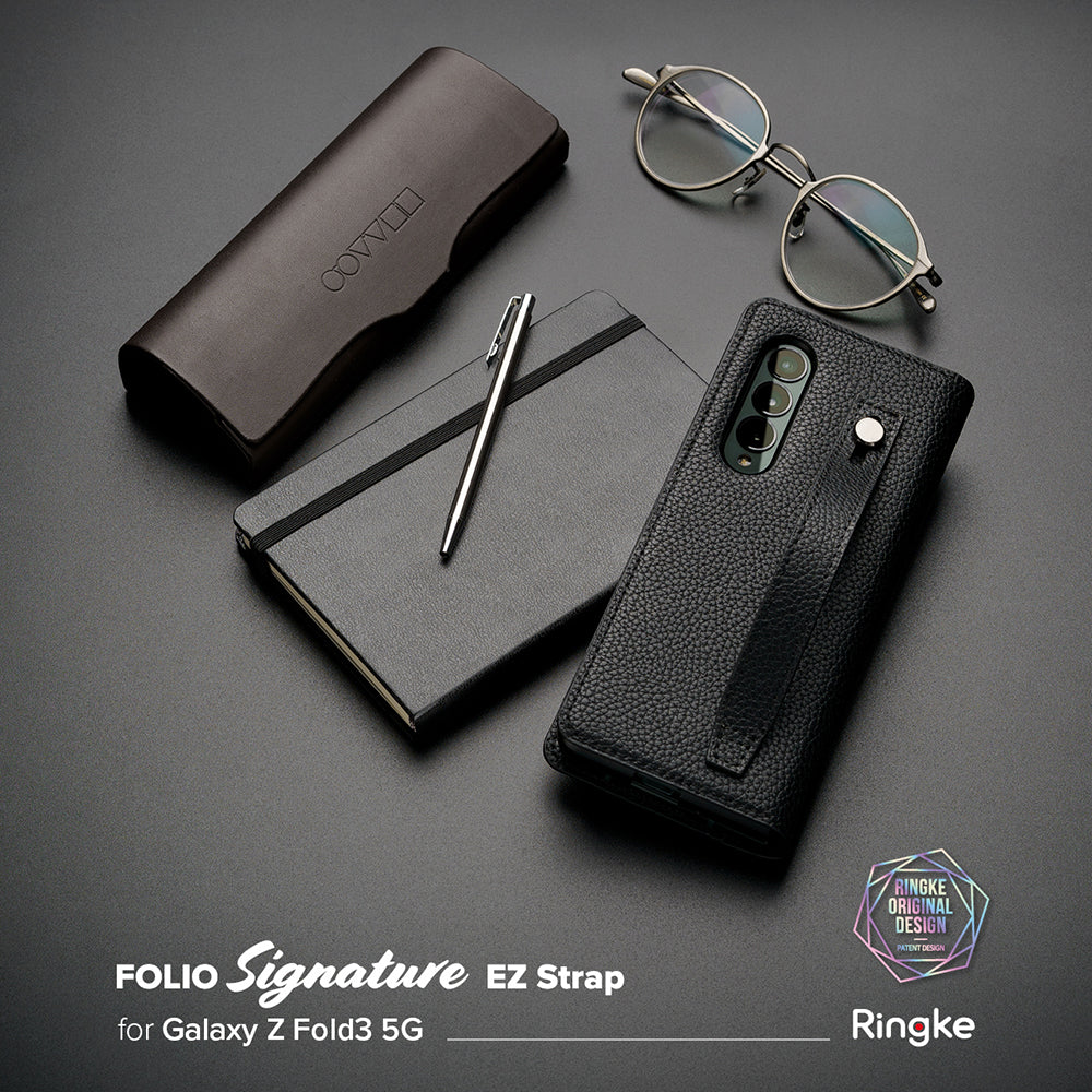 Galaxy Z Fold 3 Case | Folio Signature EZ Strap - Black textured phone case with strap, notebook, pen, and glasses.