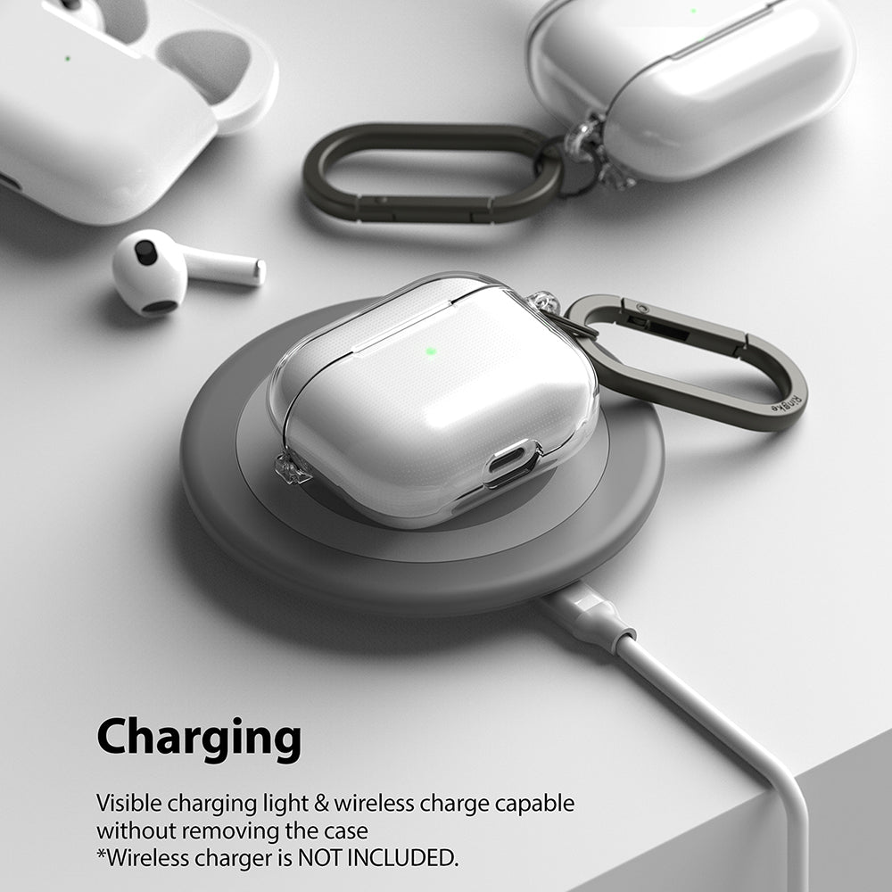 AirPods 3 Case | Hinge - Clear AirPods 3 case with carabiner charging wirelessly on a grey circular pad.