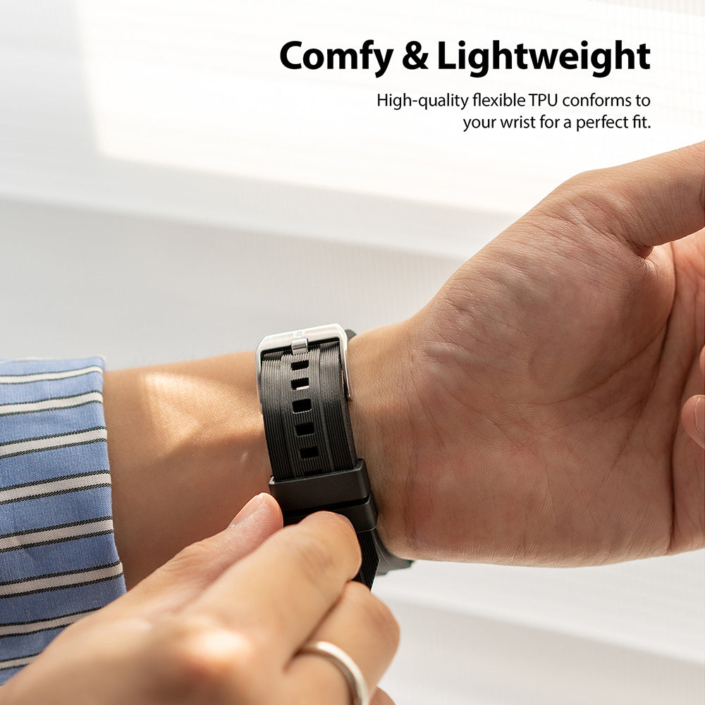 Apple Watch 49·46·45·44·42 mm | Rubber One Band - Close-up of a person fastening a black ribbed rubber watch band.