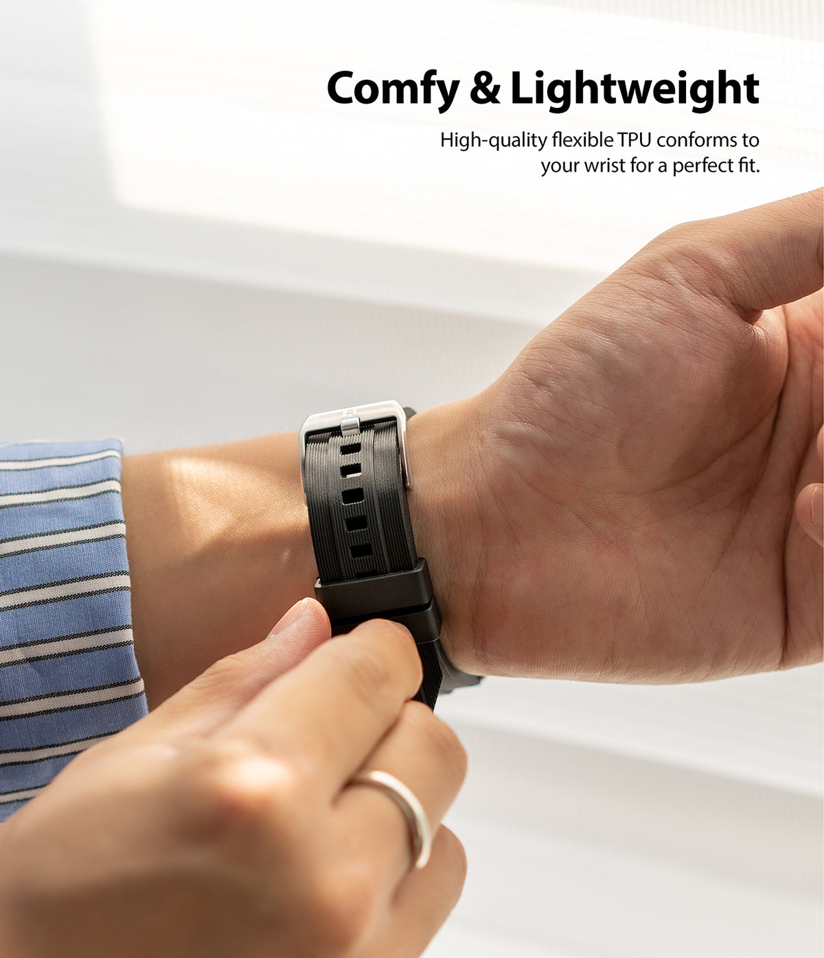 Apple Watch 42·41·40·38 mm | Rubber One Band - A person adjusting a black ribbed rubber watch band on their wrist.