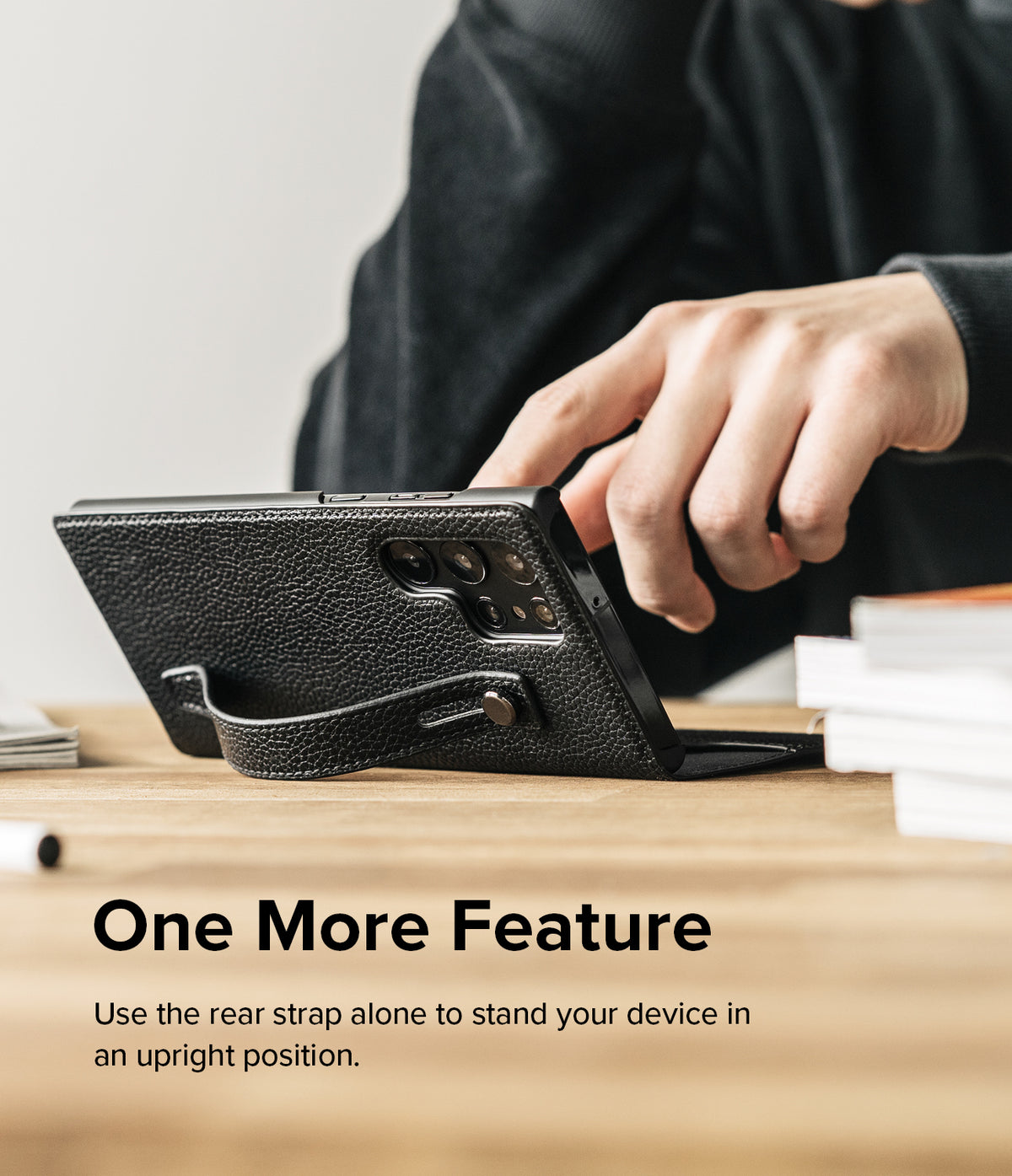 Galaxy S22 Ultra Case | Folio Signature EZ Strap - Black leather phone case with a rear strap propping it up on a desk.