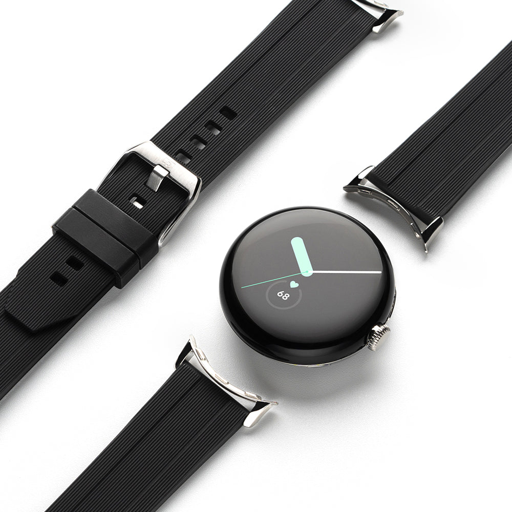Google Pixel Watch | Rubber One Band - A black circular smartwatch face surrounded by detached, ribbed black rubber watch straps.