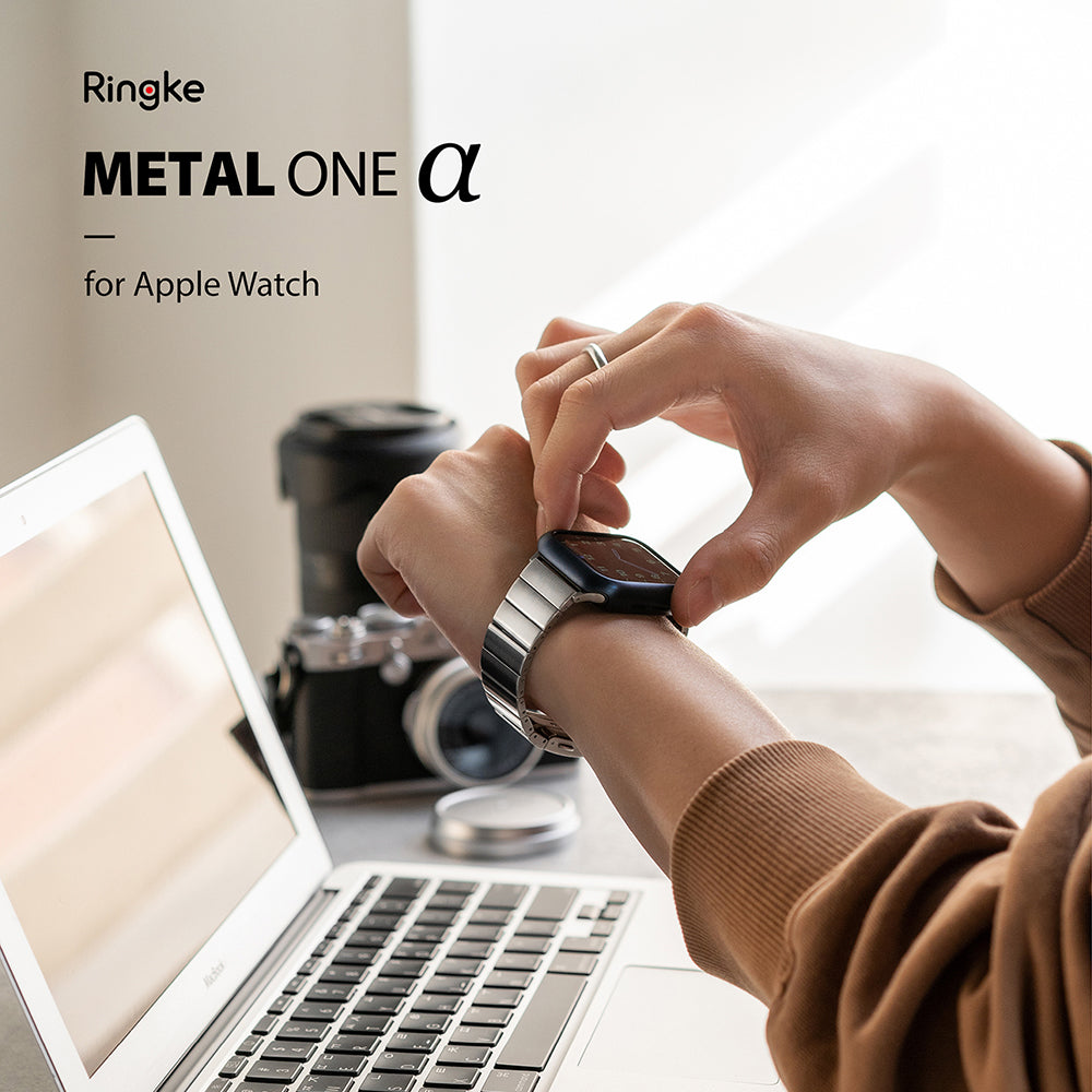 Apple Watch 49·46·45·44·42 mm | Metal One Band α - Silver - Person adjusting a silver metal watch band on their wrist.