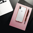 iPhone X Case | Fusion - Rose gold iPhone X in a clear case resting on a pink striped notebook with a pen and laptop.