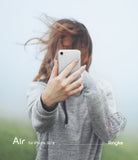 iPhone SE 2022 5G / SE 2020 / 8 Case | Air - Person holding a clear phone case over their face against a misty background.