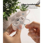 Ringke Airpods Pro Dust Guard Sticker - Hands applying a metallic dust guard sticker to an open AirPods Pro charging case.