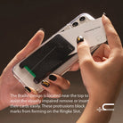 Card Holder | Slot [Solid - 2 Cards] [1 Pack] - Hands inserting a card into a black adhesive holder on a clear phone case.